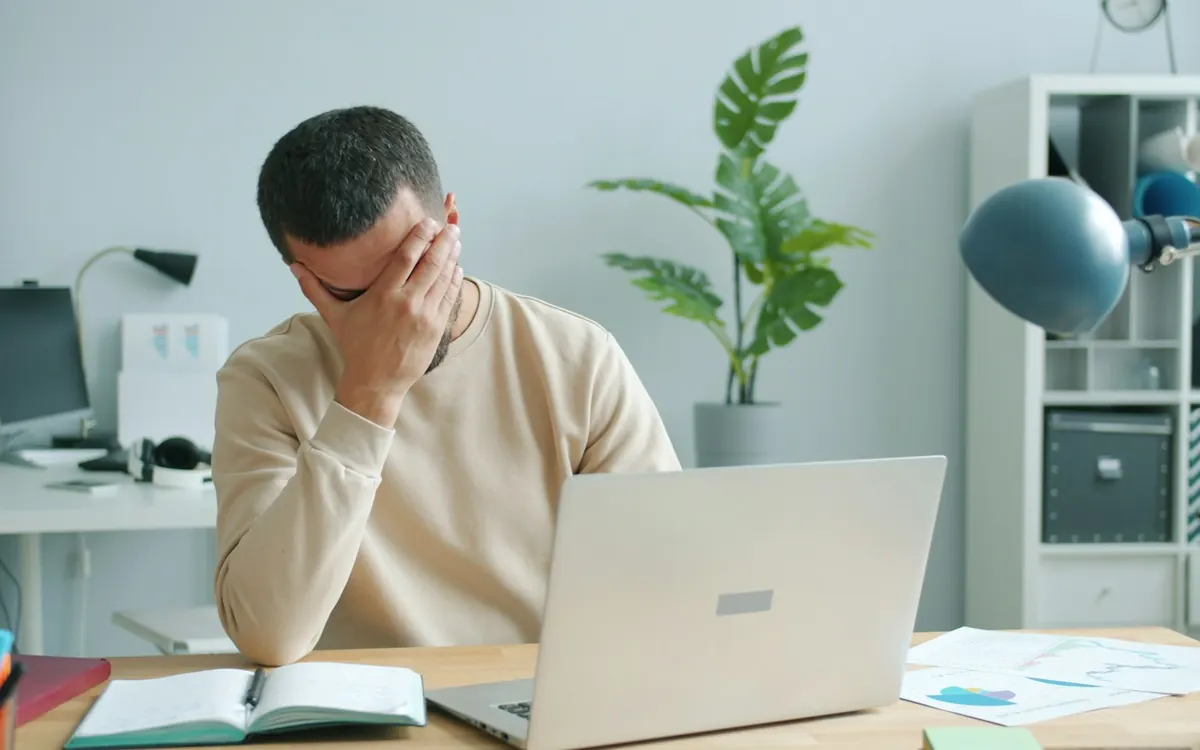 Pessoa frustrada com o Wi-Fi fraco no notebook em casa